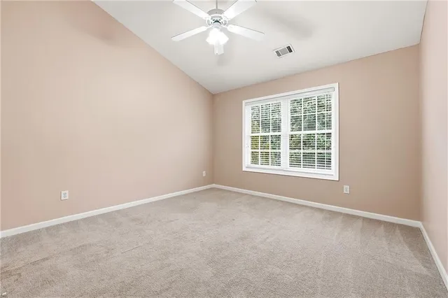 an empty room with a window and a ceiling fan
