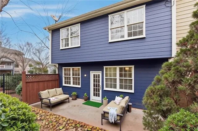 a view of a brick house with a chairs in patio