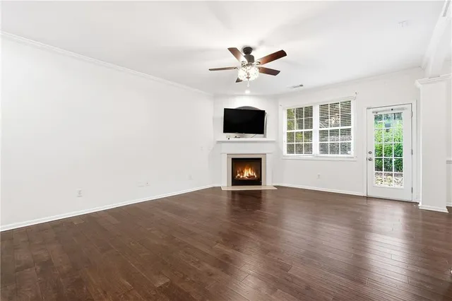 an empty room with windows fireplace and wooden floor