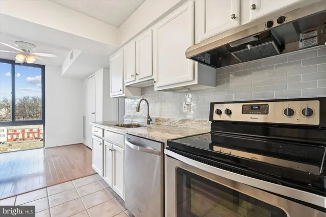 a kitchen with stainless steel appliances kitchen island granite countertop a refrigerator and a sink