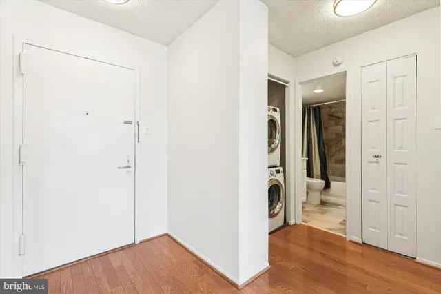 a view of a hallway with closet and wooden floor