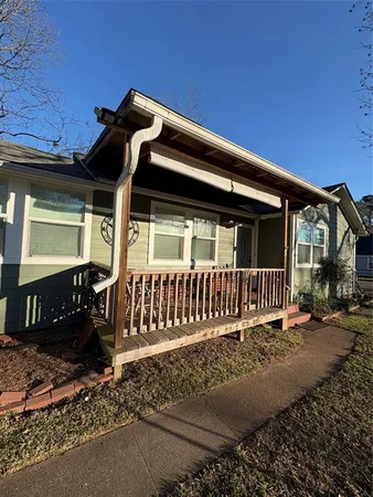 a view of a house with a small yard and wooden fence
