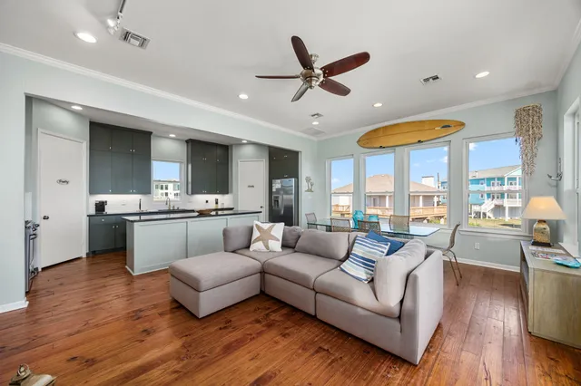 a living room with furniture kitchen view and a large window
