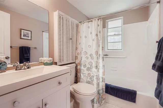 a bathroom with a sink toilet double vanity and shower
