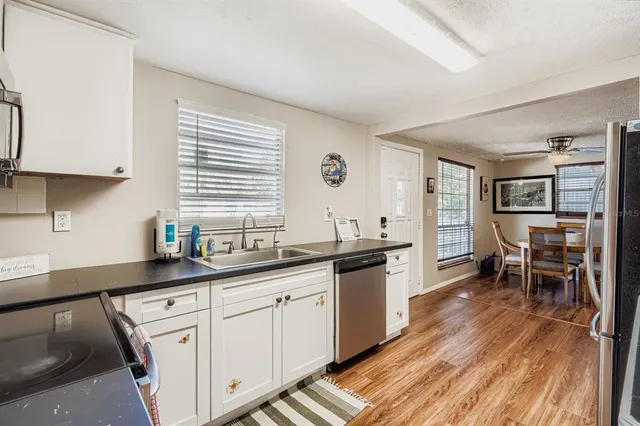 a kitchen with white cabinets and sink