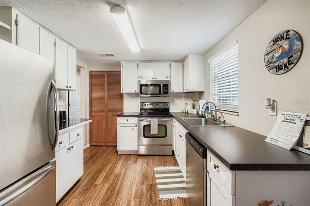 a kitchen with stainless steel appliances a stove microwave and a refrigerator