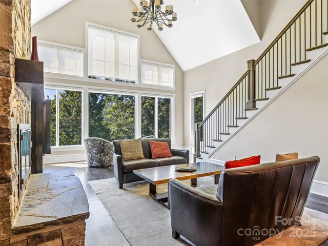 a living room with furniture stairs and a large window