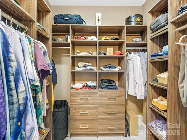 a view of walk in closet with clothes and shoes