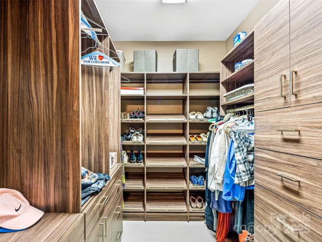 a view of walk in closet with clothes and shoes