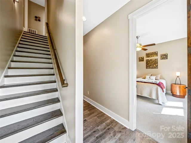 a view of a hallway with staircase and white walls