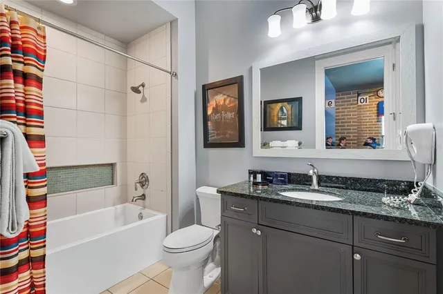 a bathroom with a granite countertop sink a toilet a mirror and shower