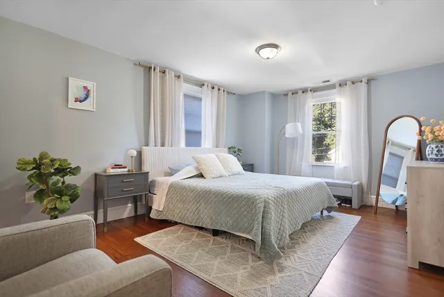 a bedroom with a bed wooden floor and window