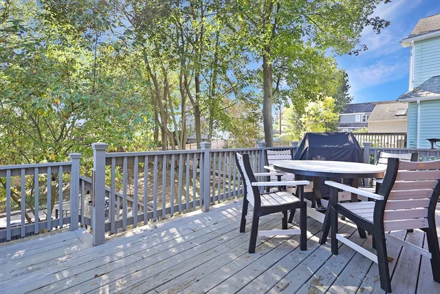 a view of a roof deck with table and chairs and wooden floor