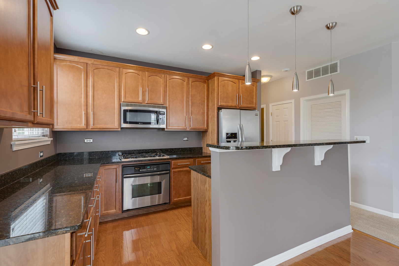 1382 Scarboro Road, Unit 1006 Schaumburg, IL 60193 - Photo 3 of 16 a kitchen with stainless steel appliances granite countertop a refrigerator a stove a sink and a microwave