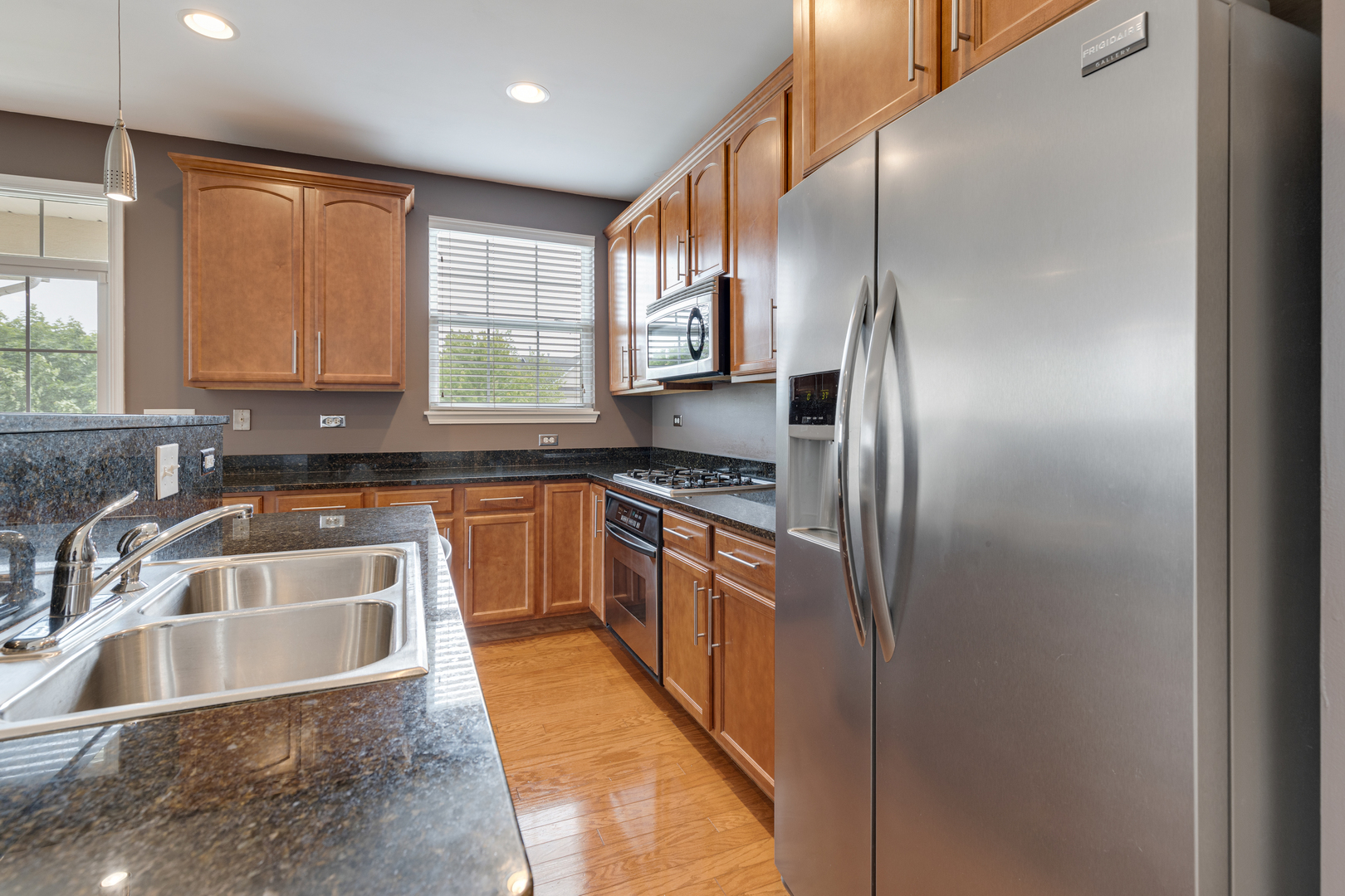 1382 Scarboro Road, Unit 1006 Schaumburg, IL 60193 - Photo 4 of 16 a kitchen with stainless steel appliances granite countertop a sink a stove and a refrigerator with cabinets