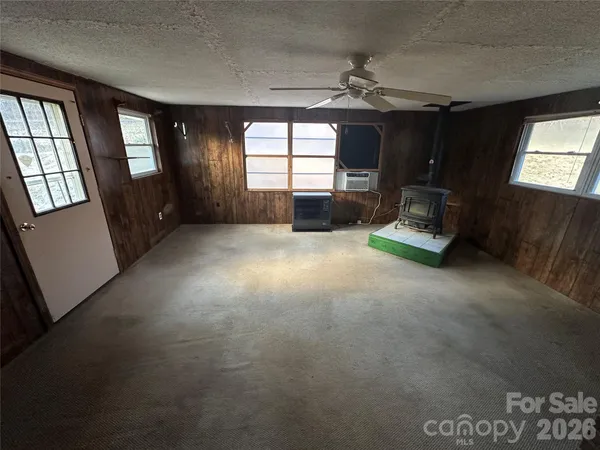 an empty room with windows and fireplace