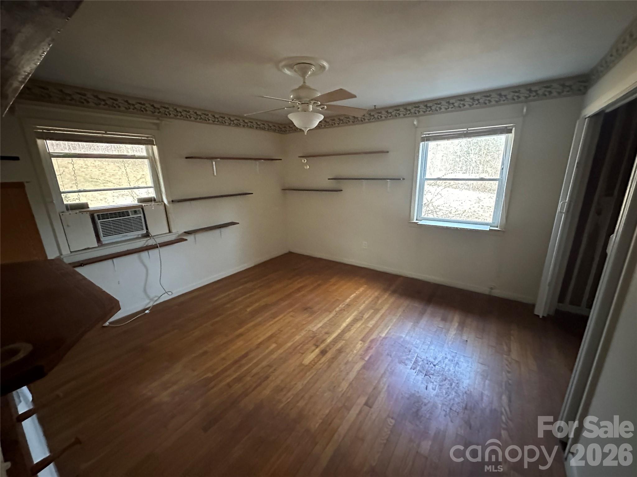 129 Ridgecrest Avenue Marble, NC 28905 - Photo 15 of 24 an empty room with wooden floor fan and windows