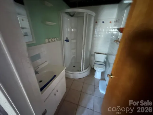 a bathroom with a granite countertop shower and a toilet