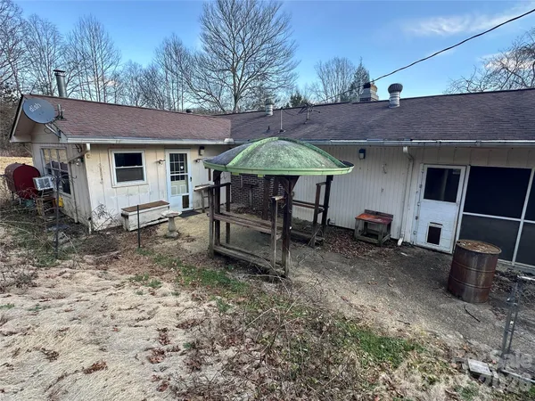 a backyard of a house with barbeque oven table and chairs