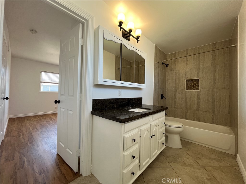 2476 Pierce Court Simi Valley, CA 93065 - Photo 11 of 18 a bathroom with a granite countertop sink a toilet a mirror and bathtub