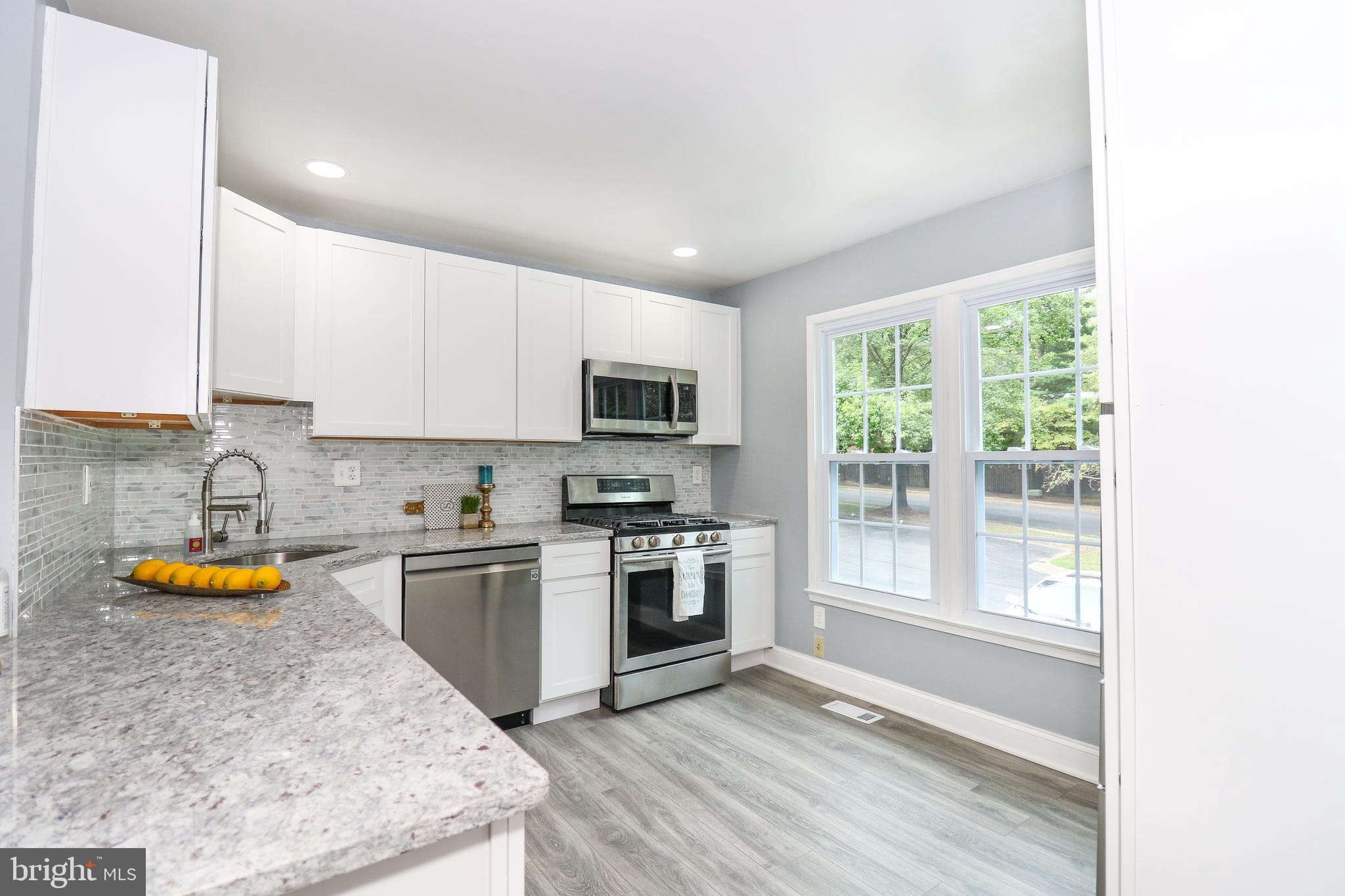 2309 Ravensdon Court Reston, VA 20191 - Photo 15 of 76 a kitchen with stainless steel appliances granite countertop a stove a sink and a microwave