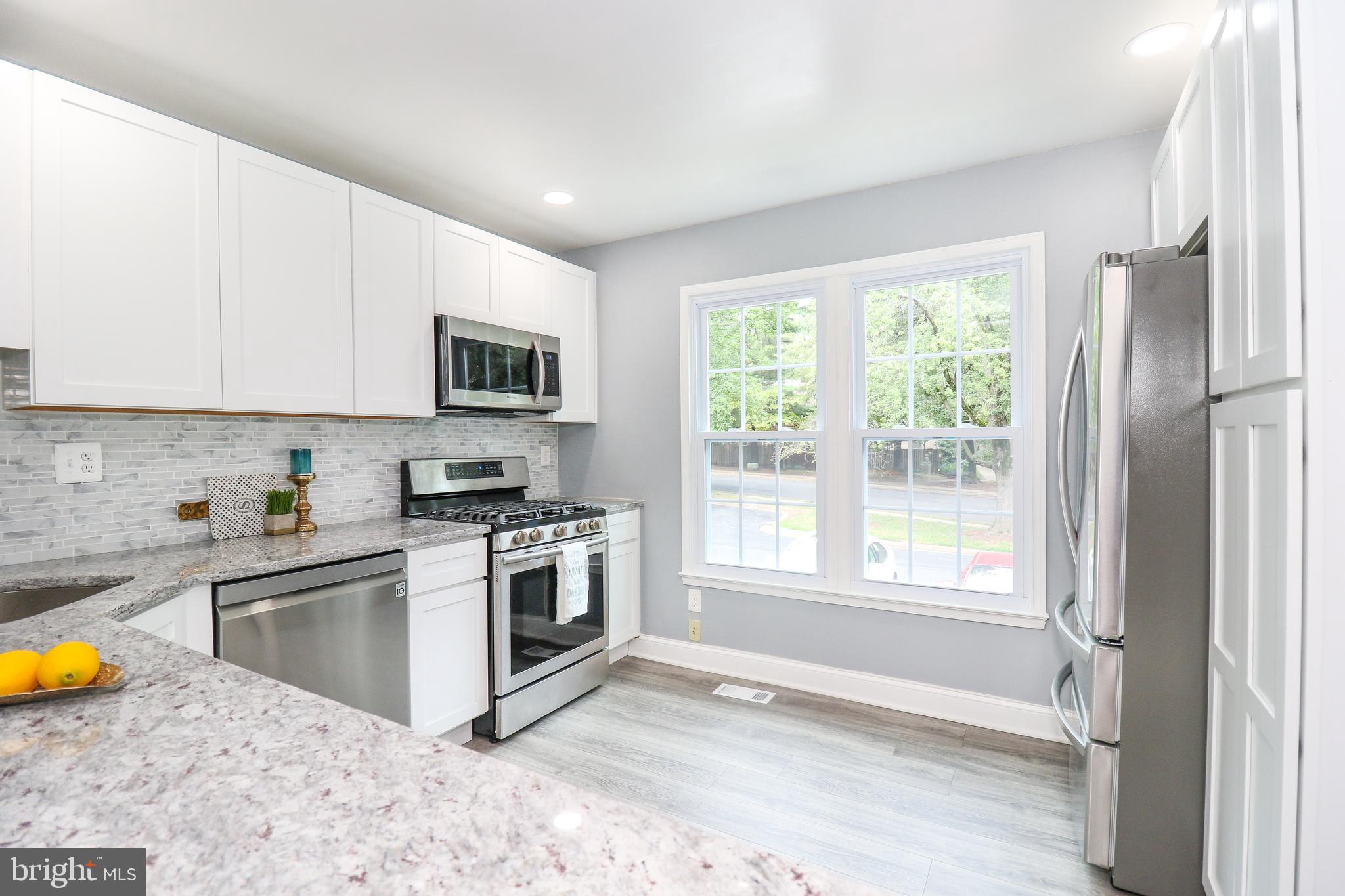 2309 Ravensdon Court Reston, VA 20191 - Photo 17 of 76 a kitchen with stainless steel appliances granite countertop a stove a sink and a microwave