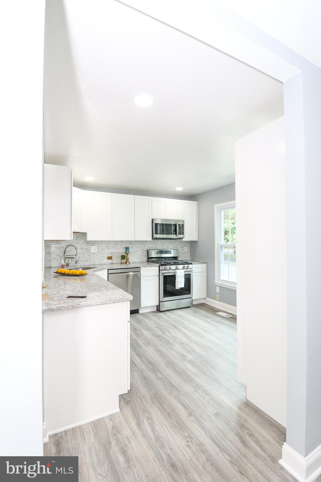 2309 Ravensdon Court Reston, VA 20191 - Photo 5 of 76 a kitchen with stainless steel appliances a stove a sink and white cabinets