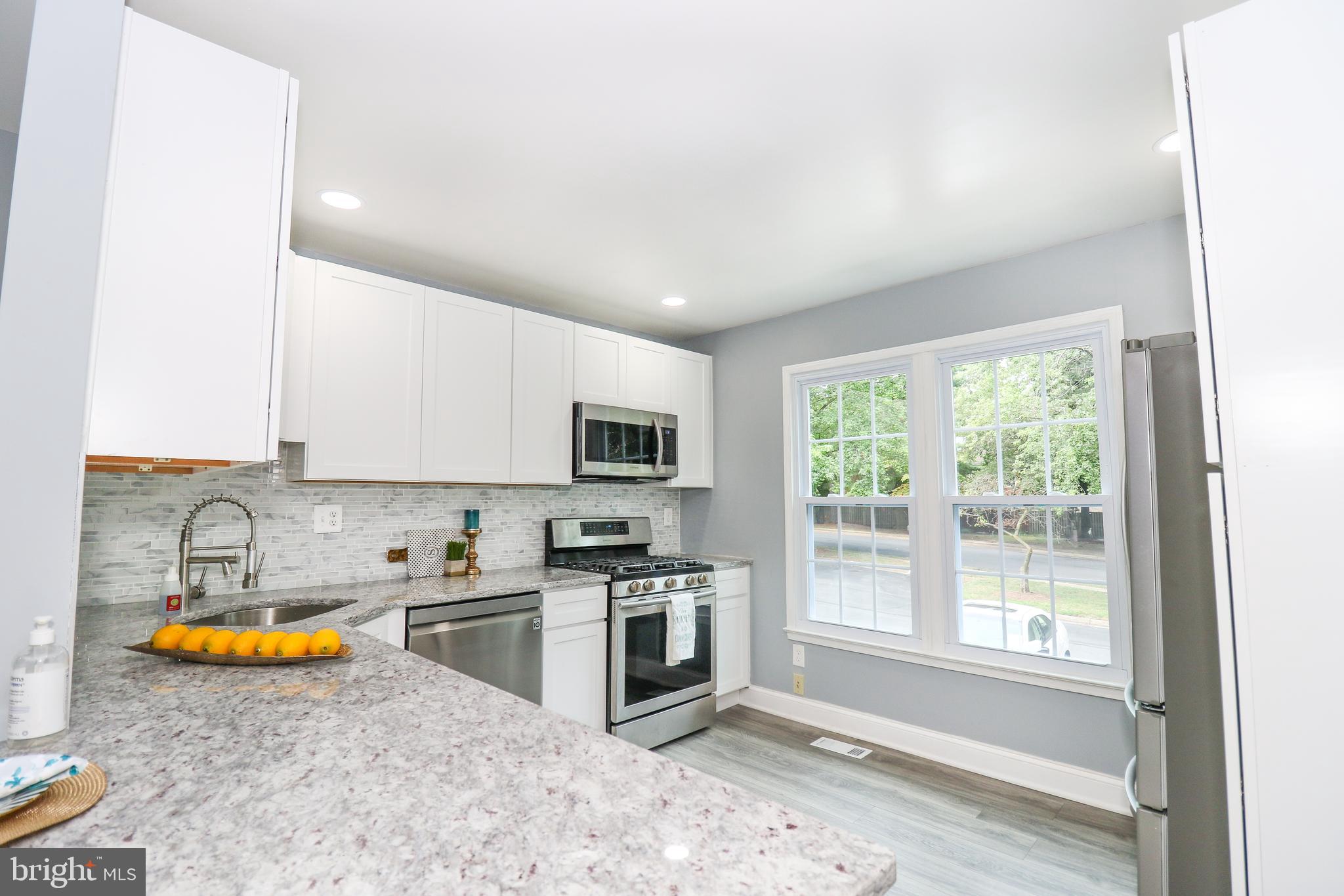 2309 Ravensdon Court Reston, VA 20191 - Photo 8 of 76 a kitchen with a sink a stove and cabinets