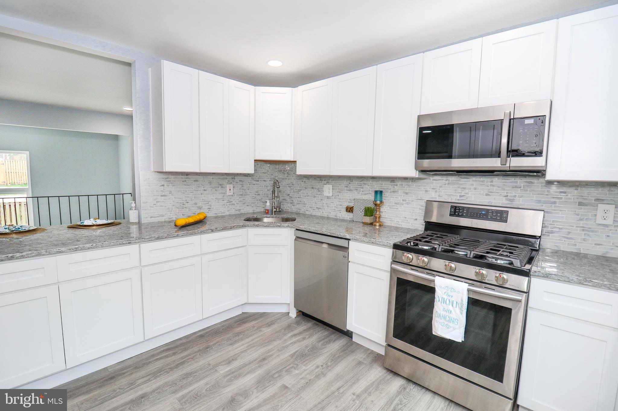 2309 Ravensdon Court Reston, VA 20191 - Photo 9 of 76 a kitchen with stainless steel appliances a stove microwave and sink