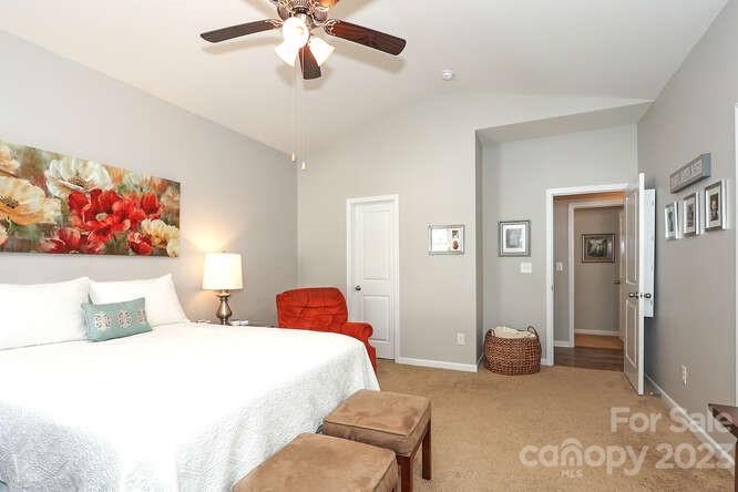 9728 Chase View Drive Matthews, NC 28105 - Photo 12 of 25 a bedroom with a bed and a chandelier