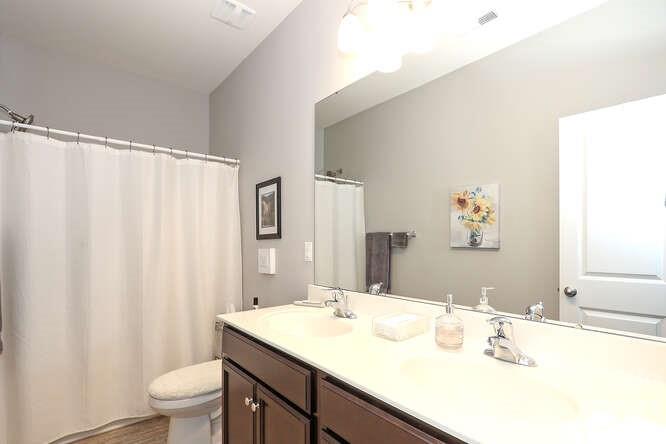 9728 Chase View Drive Matthews, NC 28105 - Photo 18 of 25 a bathroom with a granite countertop sink a toilet and a mirror