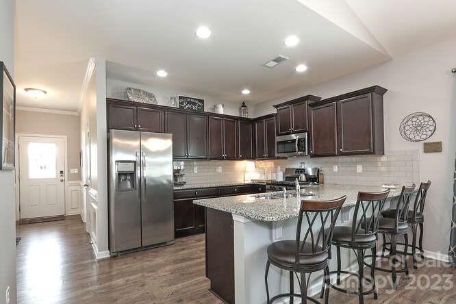 9728 Chase View Drive Matthews, NC 28105 - Photo 4 of 25 a kitchen with stainless steel appliances granite countertop a table chairs sink and cabinets