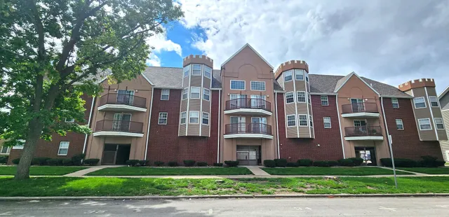 a front view of a residential apartment building with a yard
