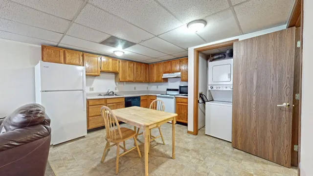 a kitchen with a refrigerator and a wooden cabinets