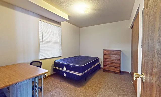 a living room with a dresser and a window