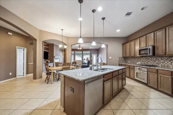 a large kitchen with a large counter top appliances and cabinets