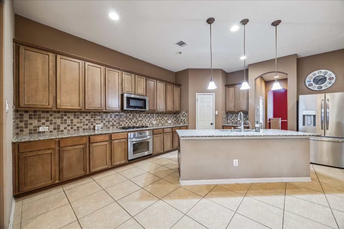 2902 Red Maple Drive Katy, TX 77494 - Photo 13 of 30 a large kitchen with kitchen island granite countertop a stove a sink a dining table and chairs