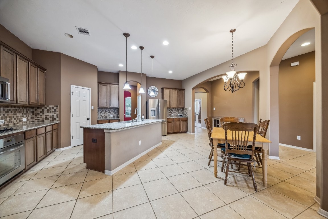 2902 Red Maple Drive Katy, TX 77494 - Photo 14 of 30 a large kitchen with cabinets chairs and stainless steel appliances