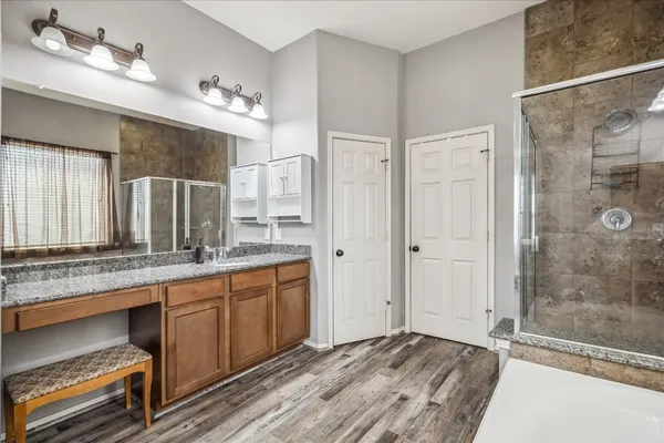 a bathroom with a granite countertop sink mirror and shower