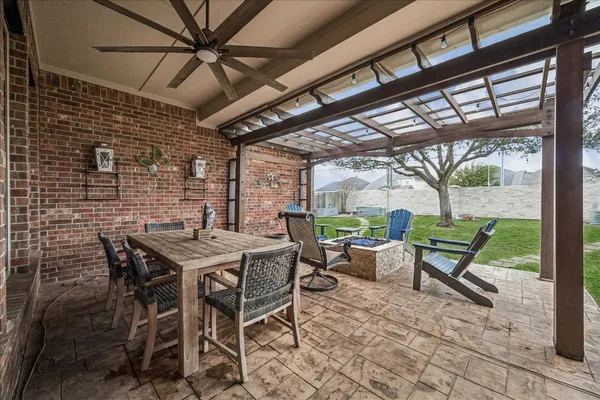 a view of a patio with a table and chairs and a barbeque