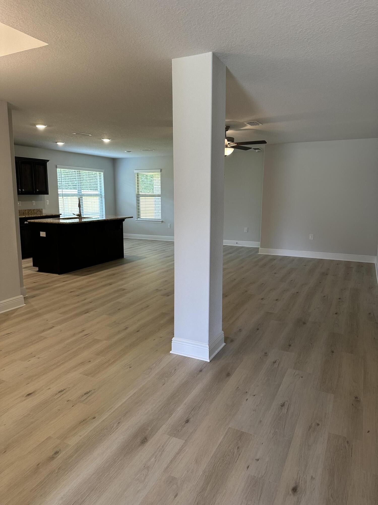 211 Baycliff Drive Crestview, FL 32536 - Photo 6 of 25 an empty room with wooden floor and windows