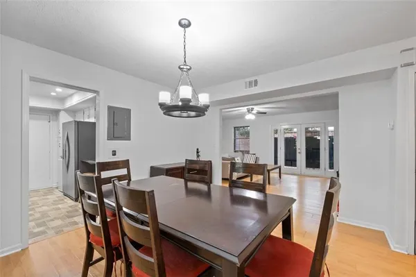 a view of a dining room with furniture a chandelier and wooden floor