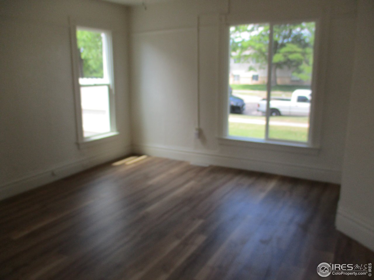 1212 6th Street Greeley, CO 80631 - Photo 3 of 20 an empty room with wooden floor and windows