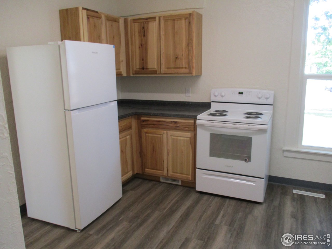 1212 6th Street Greeley, CO 80631 - Photo 7 of 20 a white refrigerator freezer and a stove sitting inside of a kitchen