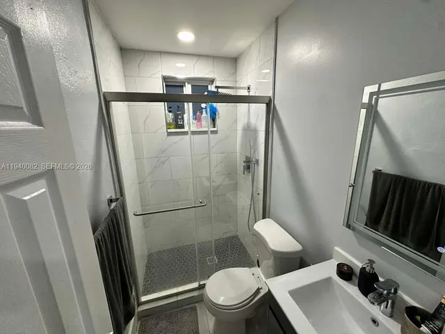 a bathroom with a sink toilet and shower