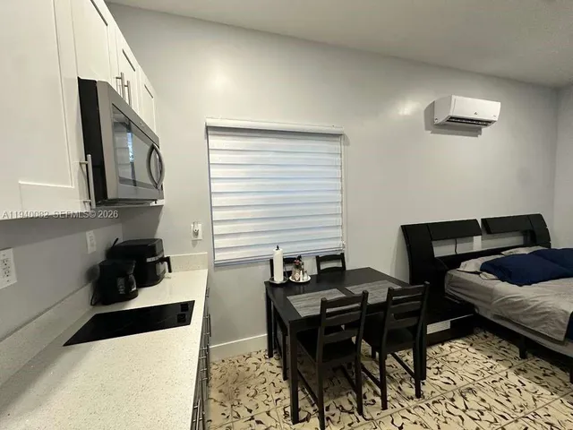 a kitchen with a table chairs and a refrigerator