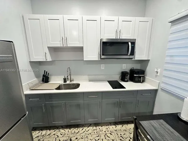 a kitchen with stainless steel appliances kitchen island granite countertop a sink and a microwave