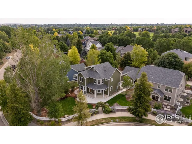 an aerial view of residential houses with outdoor space and trees