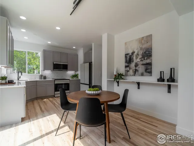 a kitchen with a table chairs microwave and cabinets