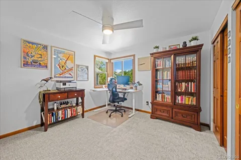 a view of a livingroom with workspace and a window